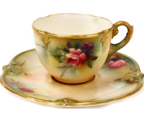 A Royal Worcester blush ivory cup and saucer, the tea cup decorated with a pink rose, gilt decoration with green Royal Worces