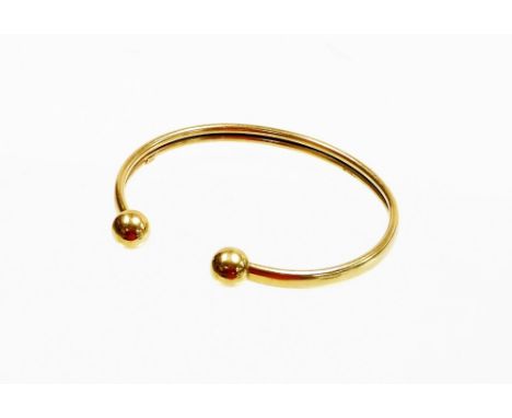 A 9ct gold torc bangle, of fold over two row twist design with ball terminals, stamped 375, 5.5cm diameter, 4.3g, boxed. 