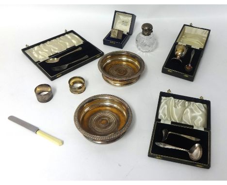 A pair EP wine bottle coasters, a silver egg cup and spoon set, cased, a silver heavy and engine napkin ring, cased etc