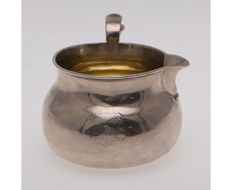 of circular bellied form, with a scroll handle, gilt interior, crested and engraved on the base with a later inscription, by 