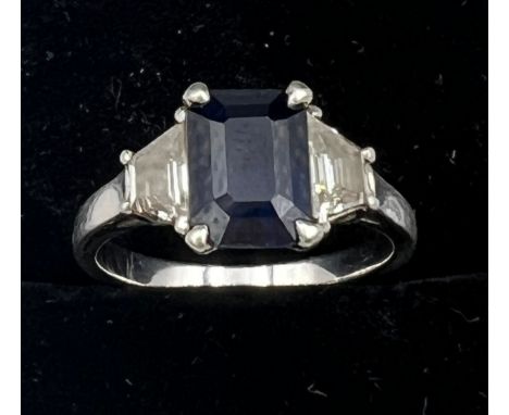 An emerald cut sapphire and baguette diamond ring, set in platinum. Size L. Weight 5gm.