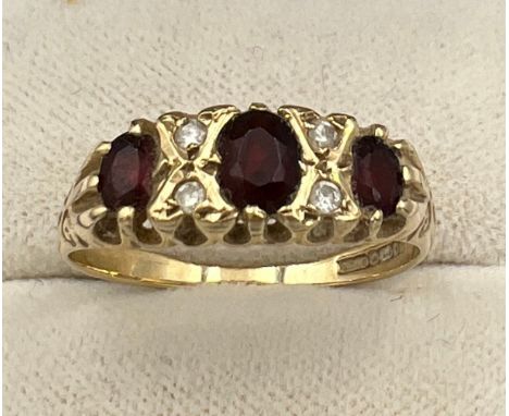 A 9 carat gold ring set with garnets and diamonds. Size O/P. Weight 2gm. 