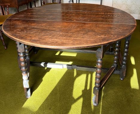 An oak gateleg dining table with bobbin turned legs. 151cm w x 190cm l x 74cm h. 