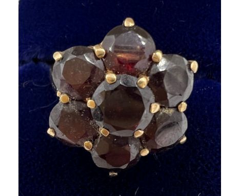 A 9 carat gold cluster ring set with dark red stones. Size N. Weight 4.2gm. 