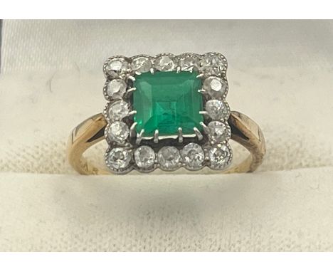 A square cut emerald and diamond ring set in unmarked yellow and white metal. Head size approximately 11cm x 11cm. Weight 3.8