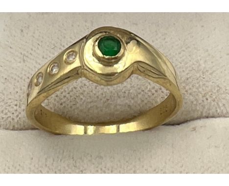 A 9 carat gold ring set with emerald and clear stones. Size P. Weight 2.8gm. 