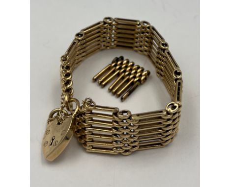 A 9 carat gold gate bracelet with extra link and heart shaped padlock with safety chain. Total weight 55.2gm. 