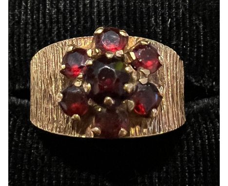 A 9 carat gold bark effect ring set with garnets. Size L. Weight 4.2gm. 