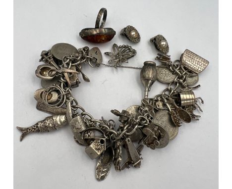 Silver charm bracelet and multiple silver charms, some opening, pair of marcasite set earrings, a single earring and an amber