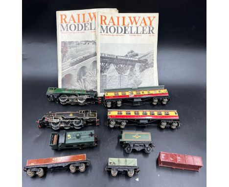 A quantity of Hornby Dublo trains and carriages together with Railway Modeller magazines in a vintage suitcase. 