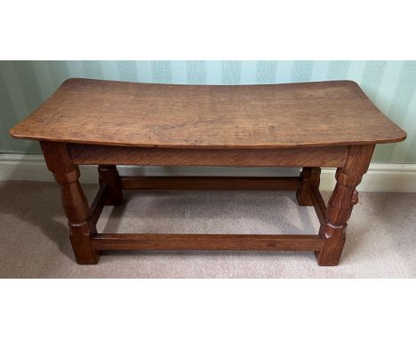 A 1960's Robert Thompson Mouseman oak seat, curved rectangular top with adzed decoration, four carved square section legs, a 