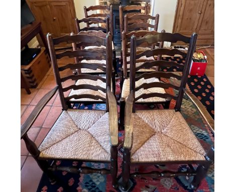 Eight oak ladder back dining chairs with rush seats to include two carvers. 