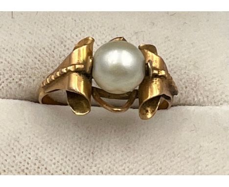 A single cultured pearl ring set in yellow metal which tests as approximately 14 carat gold. Size N. Weight 2.3gm. 