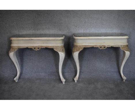 A pair of mid 20th century white painted and rococo carved console tables with inset mirrored tops on cabriole supports. H.87