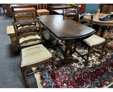 An Ercol stained elm drop leaf dining table and set of four ladder backed chairs 