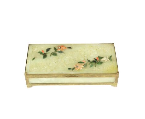 This is a Chinese jade box with hardstone inlay and brass trim. There is a floral design on the lid. Size: 7 1/2 x 3 1/2 x 1 