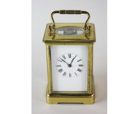 A gilt brass and bevelled glass cased carriage clock, the white enamel face with Roman numerals, 14cm high
