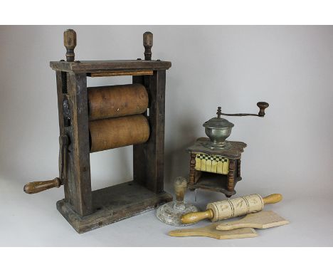 A wooden table top mangle, 49cm, a coffee grinder, a pastry shape roller, two butter pats and another kitchen item (NC)