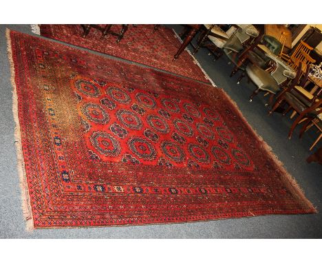 A Bokhara wool carpet with geometric motifs to centre and multi border surround in red and blue 205cm by 283cm