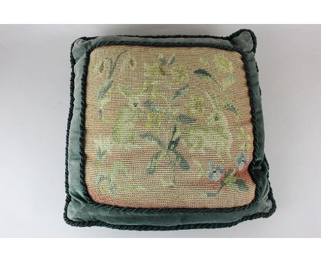 A green velvet cushion with tapestry front depicting hares in foliage