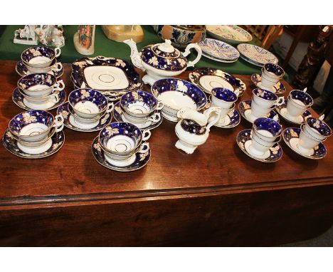 A 19th century Coalbrookdale porcelain part tea service with blue and gilt leaf design border, comprising teapot, milk jug, s