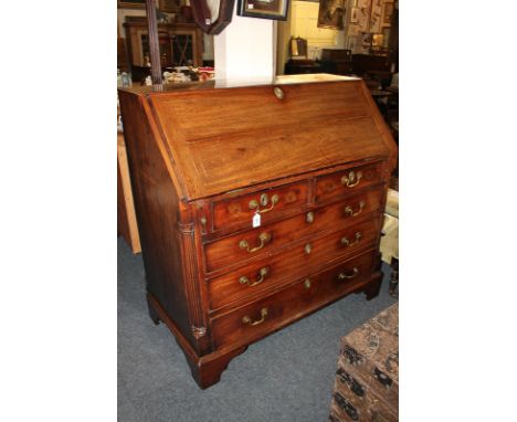 A George III mahogany bureau with fall enclosing fitted interior of pigeon holes and small drawers over two short and three l