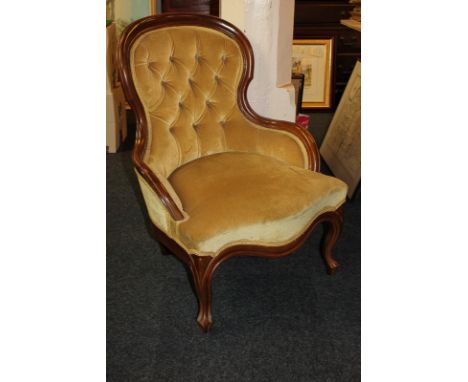 A mahogany framed button back armchair, upholstered in gold fabric, on cabriole legs