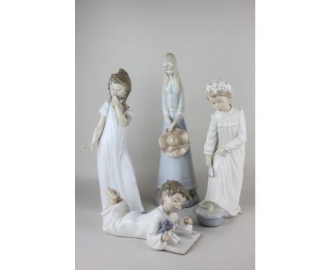 Two Nao porcelain figures of girls in nightdresses, one bathing her feet, the other yawning, a Nao figure of a boy reading a 