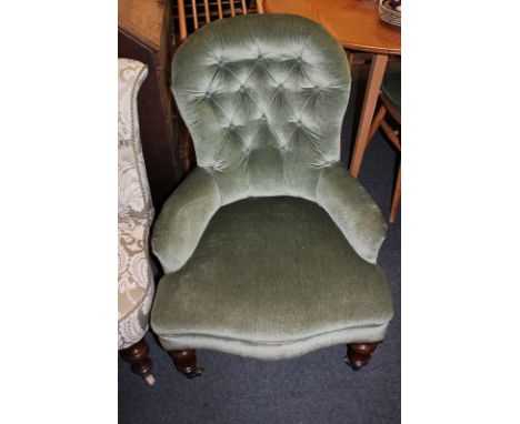 A Victorian button upholstered chair on turned legs and castors