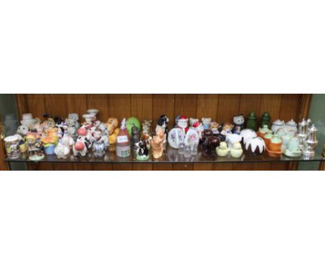 A SHELF FULL OF NOVELTY CRUETS VARIOUS 