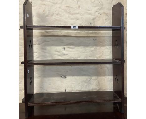 An early 20th Century stained wood wall mounted three shelf open bookcase