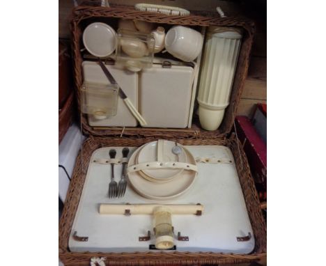 A vintage wicker picnic basket (a/f) and original contents including cups, saucers, plates, cruets, etc.
