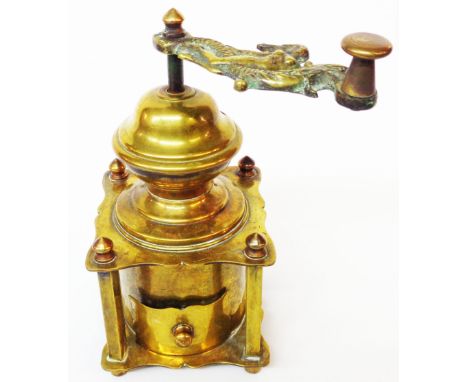 An antique brass coffee grinder of pergoda form with cast brass handle depicting a maiden riding a sea serpent and coffee dra