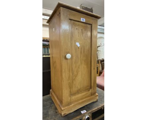 A Victorian waxed pine pot cupboard with panelled door and plinth base