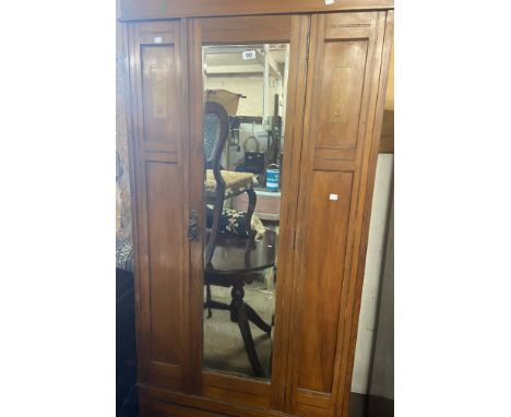A 97cm Art Nouveau inlaid walnut single wardrobe with hanging space enclosed by a bevelled mirror panel door with long drawer
