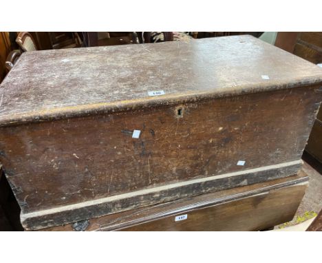 An 89cm Victorian stained pine lift-top trunk with internal candle box and flanking iron drop handles