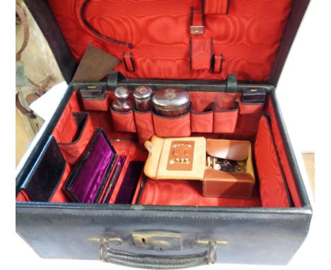 A late Victorian black leather toilet case with part fitted contents including three silver topped bottle - various assays, i