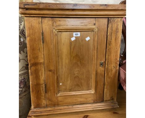 A 59cm antique waxed pine wall hanging corner cabinet with panelled door