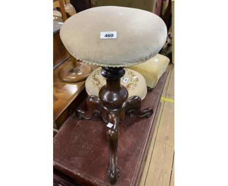 A Victorian mahogany revolving piano stool with upholstered top, set on turned pillar and tripod base