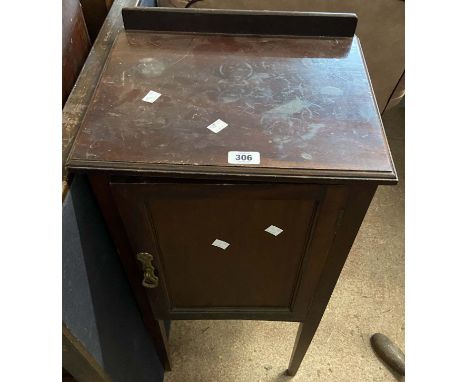 An old stained oak pot cupboard enclosed by a panelled door
