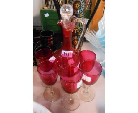 A cranberry glass claret form decanter - sold with six associated cranberry bowl wine glasses