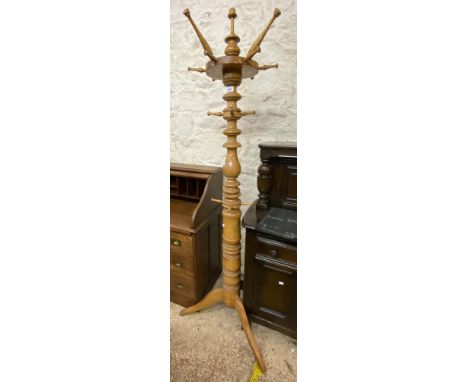 A polished blonde wood freestanding hat and coat stand with turned decoration, set on tripod base - two spindles a/f