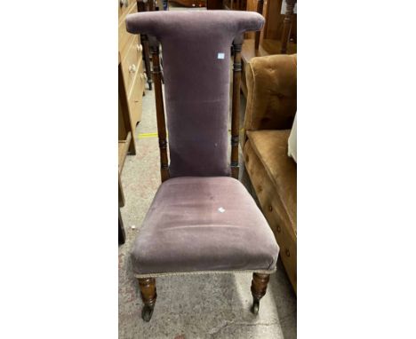 A Victorian rosewood framed prie dieu chair with velour upholstery and flanking pillar supports, set on turned front legs wit