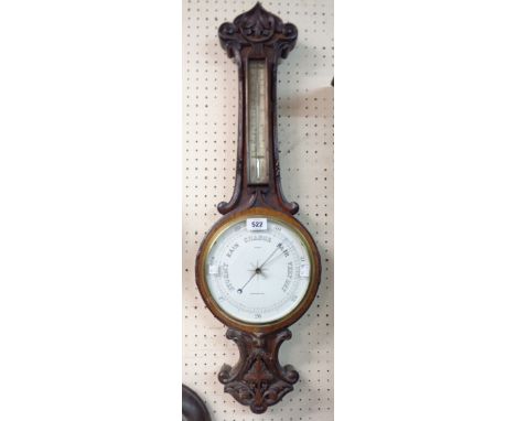 A late Victorian carved oak cased banjo barometer/thermometer, the dial marked for Ford of Barnstaple, with aneroid works