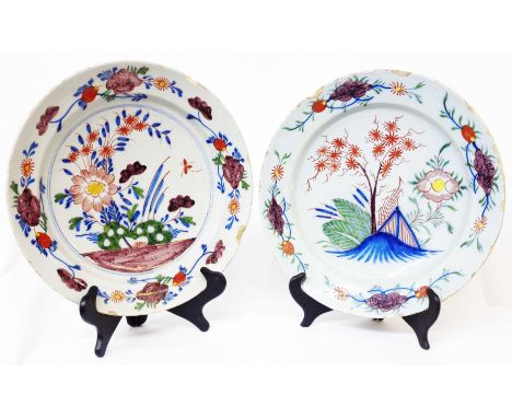 Two similar 18th Century English Delftware polychrome decorated chargers, one decorated with a tree amidst landscape, the oth