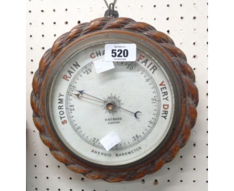 A late 19th Century oak cased wall barometer with rope twist border and printed ceramic dial marked for Hayward of Ashford, w