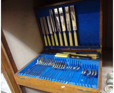 A vintage polished oak canteen containing a six place setting of silver plated cutlery