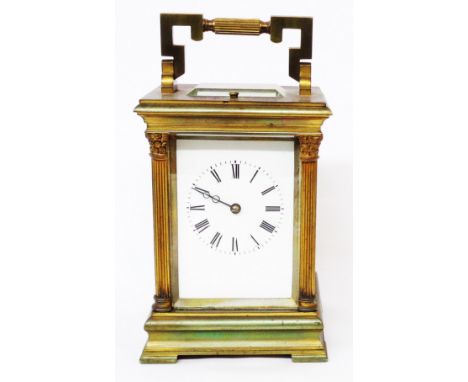 An old brass and bevelled glass cased carriage clock with Corinthian columns to corners and strike repeat eight day gong stri