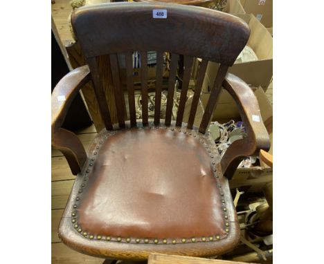 A vintage oak framed office swivel elbow chair with studded upholstered seat panel