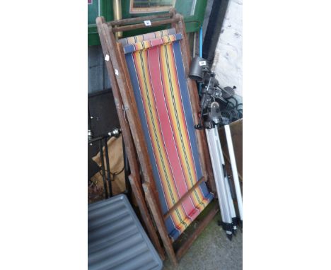 Two vintage similar folding deck chairs with stripped slung fabric